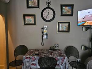 een eettafel met stoelen en een klok aan de muur bij HomeStory 3 in Casa Canovetta