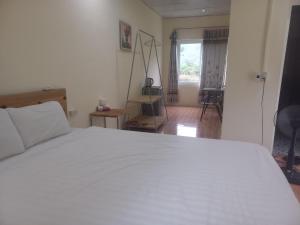 a bedroom with a white bed and a window at Trang An Pristine View homestay in Ninh Binh
