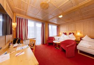 a hotel room with a bed and a table at Hotel Latini in Zell am See