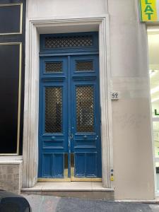 eine blaue Tür an der Seite eines Gebäudes in der Unterkunft Montmartre Sacré Cœur - Appartement Martyrs in Paris
