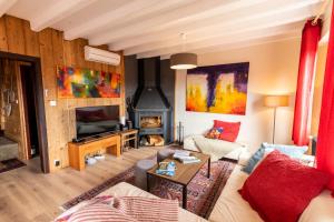 a living room with a couch and a fireplace at Le refuge du peintre in Gérardmer