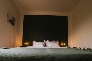 1 dormitorio con 1 cama grande con almohadas blancas en Villa Vagabondo, en Garda
