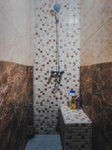 een badkamer met een douche en een bank. bij CHILL SURFER HOSTEL in Tamraght Ouzdar