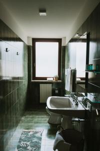 baño con bañera, lavabo y ventana en Villa Vagabondo, en Garda