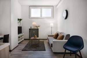 uma sala de estar branca com um sofá e uma televisão em Bracco11 em Milão