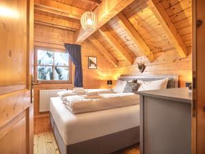 a bedroom with a bed in a wooden cabin at Alpenglück Chalet Schladming - Dachstein by AA Holiday Homes in Sankt Martin am Grimming
