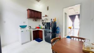a kitchen with two refrigerators and a table in it at sunset beach house in Phú Quốc