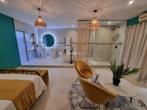 - une chambre avec un lit et une salle de bains pourvue d'une baignoire dans l'établissement Club Cocomo, à Hartbeespoort