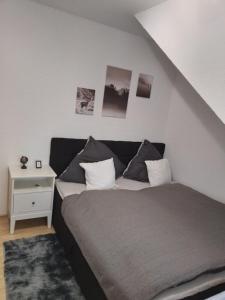 a bedroom with a bed and a white night stand at NEU! Moderne Ferienwohnung am Teufelsstein in Patersberg