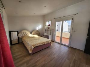 beau duplex في Deli Ibrahim: غرفة نوم بسرير وباب زجاجي منزلق