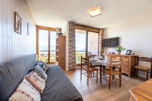 a living room with a couch and a table at Le Goléon - pistes accessibles à pied in La Toussuire