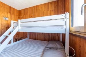 a bunk bed in a room with wooden walls at Le Goléon - pistes accessibles à pied in La Toussuire