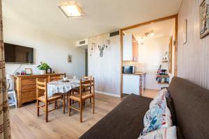 un salon avec une table et une cuisine dans l'établissement Le Goléon - pistes accessibles à pied, à La Toussuire
