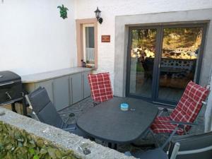a patio with a table and chairs and a grill at Nordblue 8 in Altwarp +7 photos