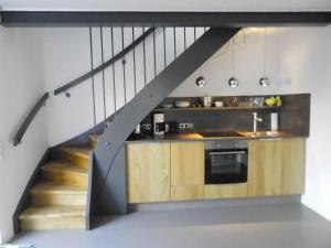 a kitchen with a staircase leading up to a loft at Susanne Hendus in Neustadt in Holstein