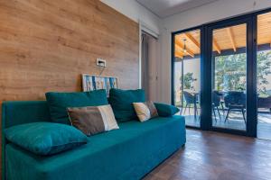 Sofá azul en la sala de estar con puertas correderas de cristal en Luxury Sea View Kasthouses - Happy Rentals, en Mali Lošinj