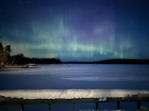 un'immagine dell'aurora nel cielo sopra un lago di Chalet Norva a Rovaniemi