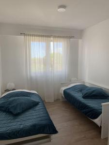 een slaapkamer met 2 bedden en een raam bij Bel appartement au bord de l'Allier classé 4* in Vichy