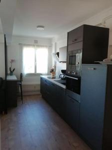 een keuken met een fornuis en een magnetron bij Bel appartement au bord de l'Allier classé 4* in Vichy