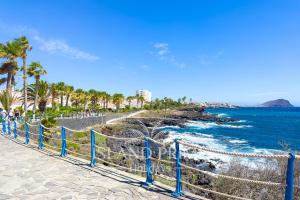 a beach with a fence next to the ocean at 3x Bedrooms Seaviews Relax in Amarilla Golf in San Miguel de Abona