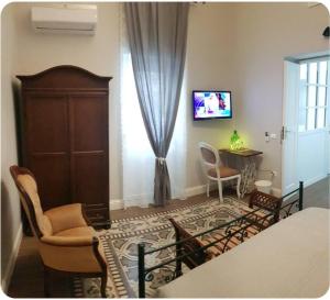 a living room with a bed and a table and a tv at Belle Époque in Taranto