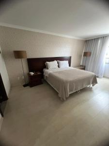 巴西利亞的住宿－Brasil 21 suite flat，一间卧室配有一张大床和两盏灯。
