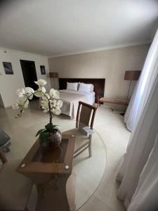 Brasil 21 suite flat في برازيليا: غرفة في الفندق بها سرير وطاولة بها زهور