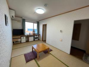 a living room with a table and a television at LiVEMAX RESORT Shiretoko Sea Front in Rausu