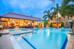 a swimming pool in front of a house at Amansara Private Resort in Pansol