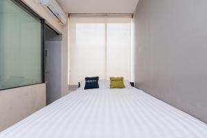 1 dormitorio con 1 cama con 2 almohadas en Urbanview Hotel Ellegan Residence Alam Sutera Serpong, en Kampungklapa 2