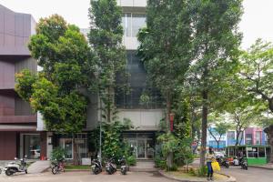 un edificio con árboles delante de él en Urbanview Hotel Ellegan Residence Alam Sutera Serpong, en Kampungklapa 2