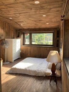 Schlafzimmer mit einem Bett und einem Fenster in der Unterkunft Olive Cottage Bao Loc in Tang Jran Dring