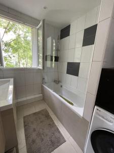 y baño con ducha, bañera y lavamanos. en Grand Appartement proche Paris, en Sèvres