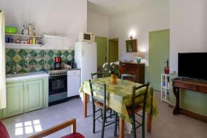 uma cozinha com uma mesa e uma cozinha com verde em Château Teillan - Cadran solaire em Aimargues