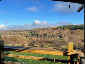 a wooden bench sitting on top of a hill at Ecosse Glamping in Crossford