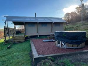a house with a gambrel roof on top of a yard at Ecosse Glamping in Crossford
