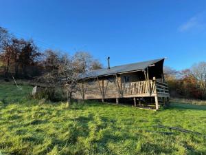 a cabin with a deck in a field at Ecosse Glamping in Crossford