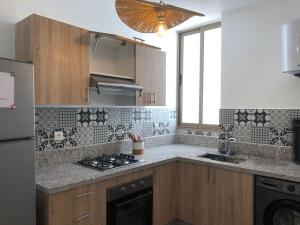 uma cozinha com um lavatório e um fogão forno superior em élégant appartement Essaouira em Essaouira