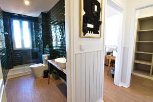 een badkamer met een wastafel, een douche en een toilet bij ArchiSuites in Coimbra