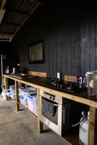 a kitchen with a wooden counter with a stove at Forest Waters Bungalow in Haruru