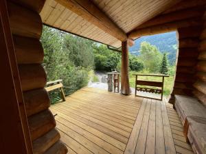 a wooden porch of a cabin with a bench on it at CHALET RONDIN in Gryon