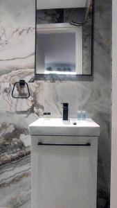 a bathroom with a white sink and a mirror at FLUMEN HOUSE - Studio Apt - Trikala in Tríkala