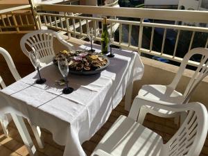 - une table avec une assiette de nourriture et des verres à vin dans l'établissement Apartment Genius Superior Ste Maxime 307, à Sainte-Maxime