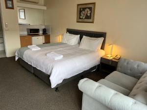 Habitación de hotel con cama y sofá en Best Western Governor Gipps Motor Inn en Traralgon