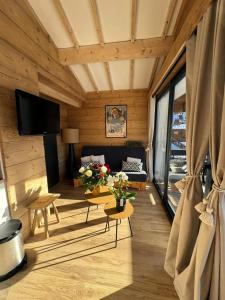 a living room with a couch and a table at Appartement le StelO Les Gets 6 personnes aux pieds des pistes 2 chambres in Les Gets