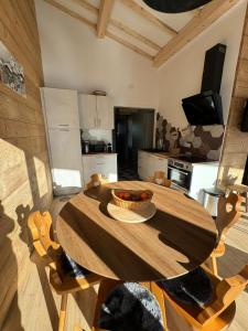 a wooden table in a kitchen with a bowl of fruit on it at Appartement le StelO Les Gets 6 personnes aux pieds des pistes 2 chambres in Les Gets