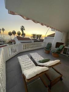 einen Balkon mit Sofa und Stühlen auf dem Balkon in der Unterkunft Ocean View near the Beach in Adeje