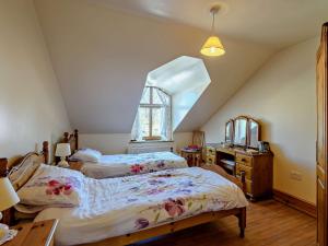 a attic bedroom with two beds and a window at 5 Bed in Blackpool 40993 in Pilling