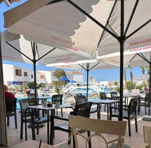 um restaurante com mesas, cadeiras e guarda-sóis em Ocean View near the Beach em Adeje