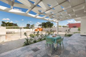 eine Terrasse mit einem Tisch und Stühlen unter einer Pergola in der Unterkunft Villa Aleida by BarbarHouse in Punta Prosciutto